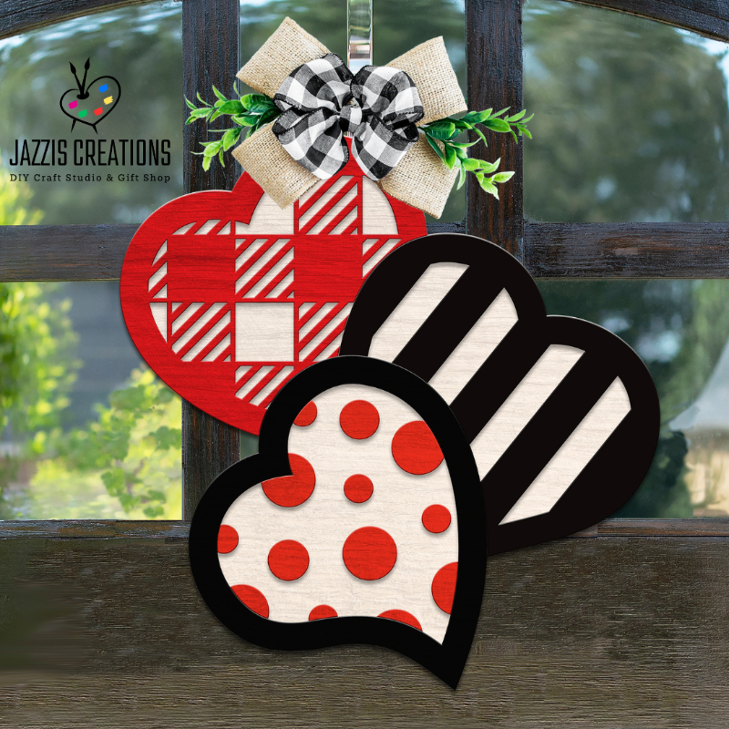 Valentine’s Day wooden door sign featuring three layered hearts with buffalo plaid, stripes, and polka dots, finished with a burlap bow and greenery accent.
