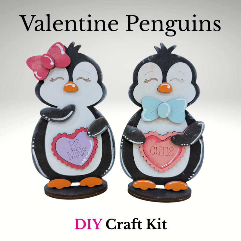 DIY Valentine penguin craft kit featuring two penguins holding heart signs that say Be Mine and Cutie, unfinished wood Valentine decor