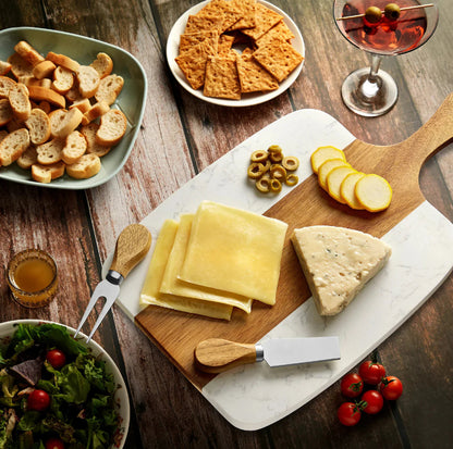 Cheese platter with sliced cheese, crackers, olives, and bread on a wooden table at jazzis creations in orange park fl