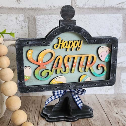 Hand-painted Happy Easter interchangeable mini stand insert with pastel eggs displayed on black wooden tabletop stand by Jazzi’s Creations