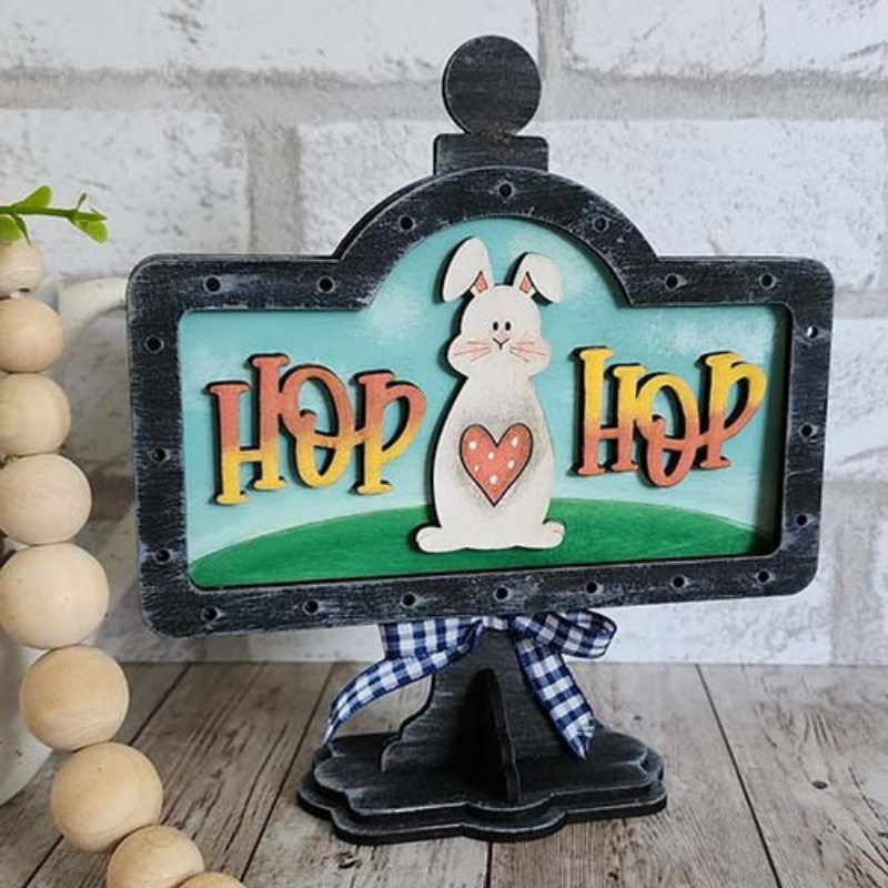 Hand-painted Hop Hop Easter bunny interchangeable mini stand insert with layered wood design displayed on black tabletop stand by Jazzi’s Creations
