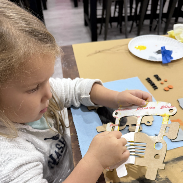 Child creating a hands-on wooden DIY craft project during a family-friendly activity at Jazzi’s Creations craft studio in Orange Park, Florida.