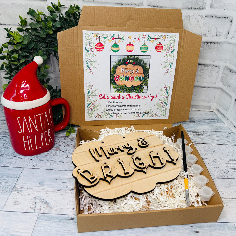 Christmas-themed gift set with wooden sign, mug, and festive decor on a white wooden surface craft kit at jazzis creations in orange park fl