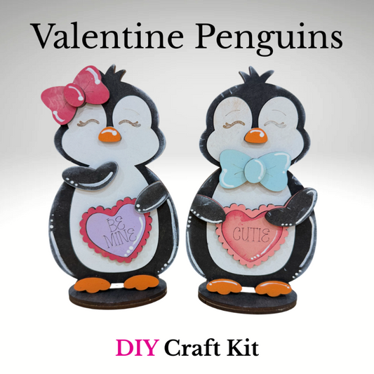 DIY Valentine penguin craft kit featuring two penguins holding heart signs that say Be Mine and Cutie, unfinished wood Valentine decor