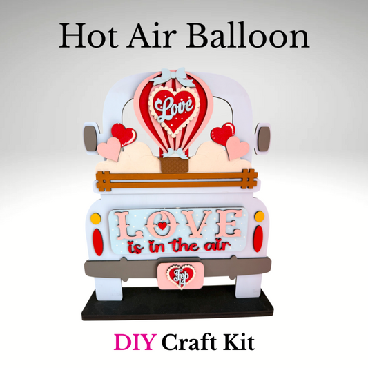 Hot air balloon craft kit with 'Love is in the air' text on a white background