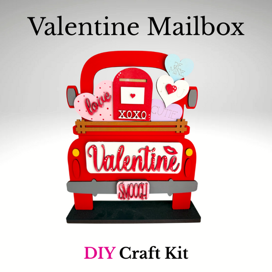 Red truck-shaped Valentine mailbox with decorative elements on a gray background, labeled 'Valentine Mailbox DIY Craft Kit'.